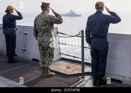 26. Dezember 2018 - Indischer Ozean - Seeleute, die dem Amphibien-Transportschiff USS Anchorage (LPD 23) der San Antonio-Klasse zugeteilt wurden, und Marines, die der 13. Marine Expeditionary Unit (MEU) zugeteilt wurden, verleihen dem Zerstörer der indischen Marine INS Rajput (D 51) während eines kooperativen Einsatzes mit der indischen Marine Ehren. Anchorage ist Teil der Essex Amphibious Ready Group (ARG) und der 13. MEU. Die Essex ARG/13th MEU ist ein fähiges und tödliches Navy-Marine-Corps-Team, das im 7. Flottengebiet eingesetzt wird, um die regionale Stabilität zu unterstützen, Partner und Verbündete zu beruhigen und eine PR zu gewährleisten Stockfoto