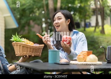 Wellness Im Freien. Freunde genießen gesunde Snacks und Lachen in einer Gartenumgebung. Stockfoto