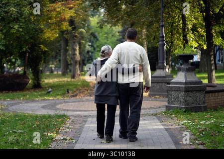 Ein älteres Paar, Mann und Frau, spazieren im Herbstpark. Stockfoto