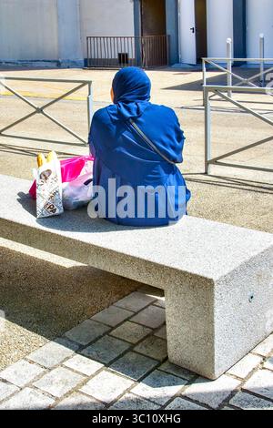 Arabische Frau auf Steinbank - Ozon, Chatellerault, Vienne (86), Frankreich. Stockfoto