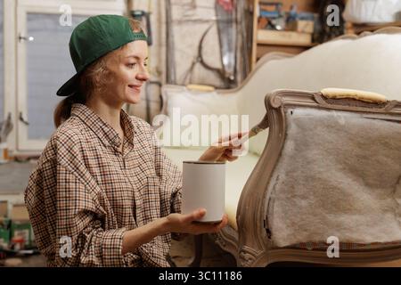 Holzmöbel mit Kreidemalerei aus menschlicher Hand. Alte Holzmöbel werden mit brandneuer, farbenfroher Kreidefarbe erneuert. Die Innendekoration wird neu gestaltet Stockfoto