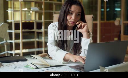 Asiatische Geschäftsfrau Planer Organisator weibliche Geschäftsfrau sprechendes Handy Beratung Kunde Online Arbeit Laptop im Büro Chinesisch Koreanisch Stockfoto