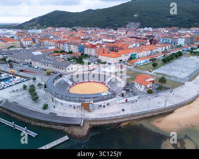 Aus der Vogelperspektive von einer Drohne auf die Stierkampfarena Santoña und den Fischerhafen. Santoña, Victoria und Joyel Marshes Naturpark. Kantabrisches Meer. Kantabrien. Spanien Stockfoto
