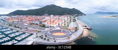 Aus der Vogelperspektive von einer Drohne auf die Stierkampfarena Santoña und den Fischerhafen. Santoña, Victoria und Joyel Marshes Naturpark. Kantabrisches Meer. Kantabrien. Spanien Stockfoto