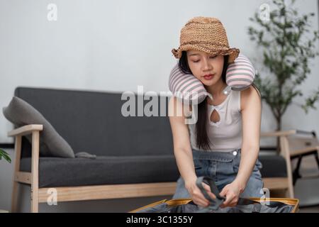 Junge Frau packt Koffer für Reise-Abenteuer zu Hause mit modernem Stil und Spannung für die kommende Reise Stockfoto