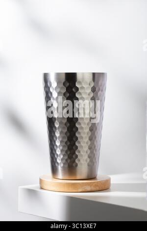 Mit diesem stilvollen, isolierten Trinkbecher aus Edelstahl können Sie Ihre Feuchtigkeit spenden. Die einzigartige gehämmerte Textur und das schlanke Design ergänzen die Natu perfekt Stockfoto