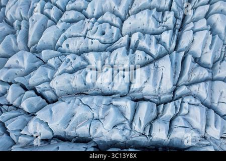 Aus der Vogelperspektive auf eine Gletschereisformation mit tiefblauen Spalten und strukturierten Oberflächen, die eine zerklüftete, überirdische Landschaft schaffen, Selfoss, Sveitarfélagið Árborg, Island. Stockfoto