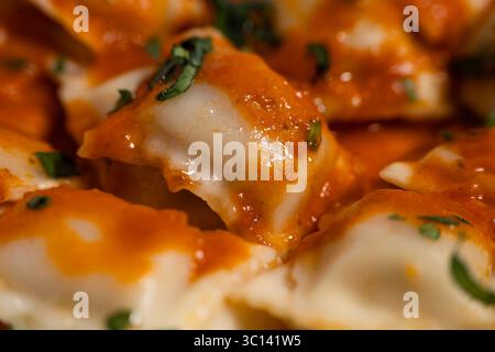 Nahaufnahme köstlicher Ravioli-Pasta mit lebendiger Tomatensauce und frischem Basilikum für ein köstliches kulinarisches Erlebnis Stockfoto