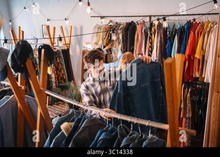 Ein stylischer junger Mann kauft heute in einem trendigen Bekleidungsgeschäft Denim Stockfoto