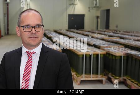 22. Juli 2025, Niedersachsen, Unterlüß: Grant Hendrik Tonne (SPD), niedersächsischer Minister für Wirtschaft, Verkehr und Bau, steht vor Artilleriegeschossen im Kaliber 155 mm und beantwortet Fragen von Medienvertretern nach einem Rundgang durch die neue Munitionsfabrik der Rüstungsfirma Rheinmetall. Der Besuch des Rüstungsunternehmens ist Teil der Sommerreise des niedersächsischen Wirtschaftsministers. Foto: Marcus Brandt/dpa Stockfoto