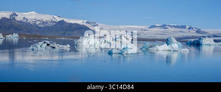 Die Jokulsarlon Glacier Lagoon zeigt atemberaubende Eisberge, die anmutig auf ruhigen Gewässern schwimmen, umgeben von majestätischen Gletschern. Das Sonnenlicht reflektiert brillante Reflexe und verbessert die ruhige Atmosphäre. Stockfoto