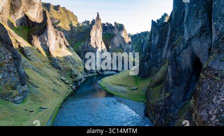 Der Fjadrargljufur Canyon bietet atemberaubende Felsformationen und einen sich windenden Fluss, umgeben von üppigem Grün. Erleben Sie die ruhige Atmosphäre und die natürliche Schönheit dieser ikonischen isländischen Landschaft. Stockfoto