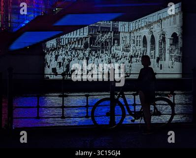 Berlin, Deutschland. Juli 2025. Am 20. Juli 2025 sehen die Menschen den Film und die Lichtprojektion im Parlamentsbezirk an der Fassade des Marie-Elisabeth-Luders-Hauses in Berlin. Vom 6. Juli 2025 bis zum 3. Oktober 2025 ist eine Laserprojektions- und Lichtshow über Ereignisse in der deutschen Parlamentsgeschichte zu sehen. (Foto: Michael Nguyen/NurPhoto) Credit: NurPhoto SRL/Alamy Live News Stockfoto