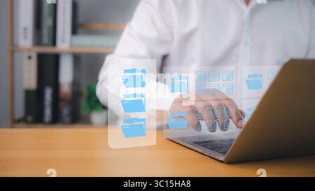 Verwaltung digitaler Dateidokumente auf einem Laptop durch professionelle Anwender, die Cloud-Computing, sichere Speicherung und effiziente Datenorganisation für moderne Unternehmen nutzen Stockfoto