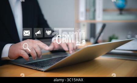 CRM-Software, die von Geschäftsleuten auf Notebooks für digitales Kundenbeziehungsmanagement, Marketinganalysen und Bürokommunikationstechnologie verwendet wird. Stockfoto