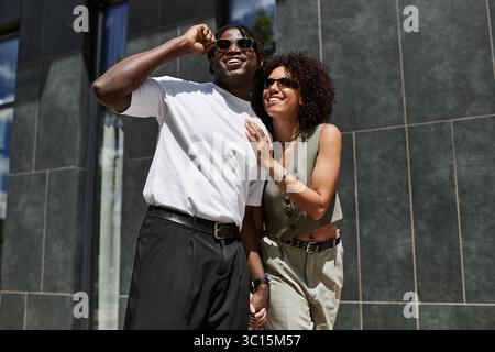Ein junges schwarzes Paar lacht und verbindet sich auf seinem Sommerausflug. Stockfoto