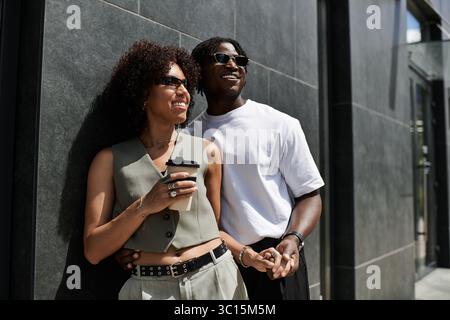 Ein junges schwarzes Paar genießt einen fröhlichen Sommertag in stilvollen Outfits in der Stadt. Stockfoto