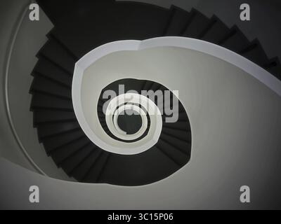 Eine von oben fotografierte Wendeltreppe, die ein abstraktes geometrisches Muster in Schwarz-weiß schuf, Treppen Wendeltreppe Stockfoto