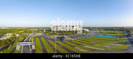 Miami Gardens, USA - 19. Juli 2025: Aus der Vogelperspektive das Hard Rock Stadium, das unter hellem Himmel glänzt, umgeben von grünen Feldern und gewundenen Rennen Stockfoto