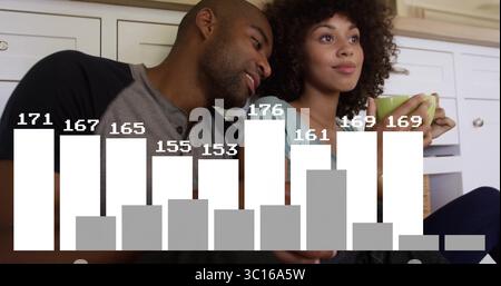 Sitzendes Paar lehnt sich an weiße untere Schränke, hält hellgrünen Becher in der gemütlichen Küche Stockfoto