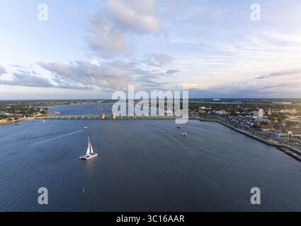 Aus der Vogelperspektive auf die Bridge of Lions, die sich über den Matanzas River erstreckt, die Boote segeln sanft, der Himmel mit sanften Blau- und Weißtönen gemalt, St. Augustine, St. Johns County, Vereinigte Staaten. Stockfoto
