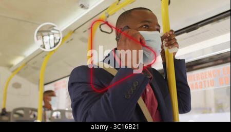 Stehender Mann, der auf dem Smartphone spricht und den gelben Handlauf im Bus mit Notausstiegsschild hält Stockfoto
