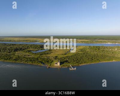 Blick aus der Vogelperspektive auf das alte Fort Matanzas an der Küste, umgeben von üppiger grüner Vegetation, wo der Fluss auf das Meer trifft, St. Augustine, Florida, USA. Stockfoto