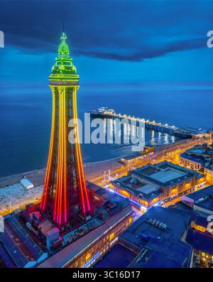 Hochwertiges Luftbild des Blackpool Tower, beleuchtet entlang der Promenade und am Meer, Lancashire, Großbritannien. Juli 2025. Stockfoto