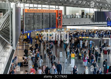 Reisebetrieb im Terminal Flughafen Frankfurt 22.07.25, Frankfurt: Symbolfoto, Illustrationsbild, Symbolbild, Illustrationsfoto, Alltagsszene Weitwinkelaufnahme vom Check-in-Bereich im Terminal 1 des Frankfurter Flughafens FRA. Zahlreiche Reisende bewegen sich mit Gepäck durch die große, lichtdurchflutete Halle, nutzen die Check-in-Automaten oder stehen in der Warteschlange. Im Hintergrund befinden sich eine große Anzeigetafel mit Abflügen, Werbeflächen sowie der Schalterbereich verschiedener Airlines, unter anderem Lufthansa. Das Bild zeigt den typischen Betrieb eines internationalen Flughafens Stockfoto