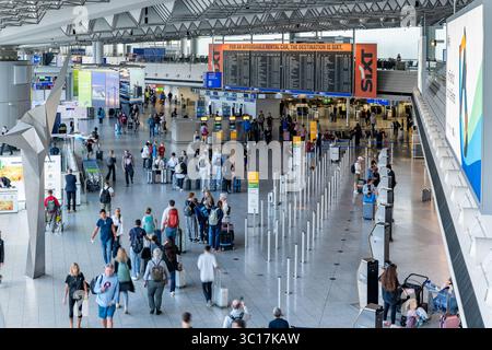 Reisebetrieb im Terminal Flughafen Frankfurt 22.07.25, Frankfurt: Symbolfoto, Illustrationsbild, Symbolbild, Illustrationsfoto, Alltagsszene Weitwinkelaufnahme vom Check-in-Bereich im Terminal 1 des Frankfurter Flughafens FRA. Zahlreiche Reisende bewegen sich mit Gepäck durch die große, lichtdurchflutete Halle, nutzen die Check-in-Automaten oder stehen in der Warteschlange. Im Hintergrund befinden sich eine große Anzeigetafel mit Abflügen, Werbeflächen sowie der Schalterbereich verschiedener Airlines, unter anderem Lufthansa. Das Bild zeigt den typischen Betrieb eines internationalen Flughafens Stockfoto