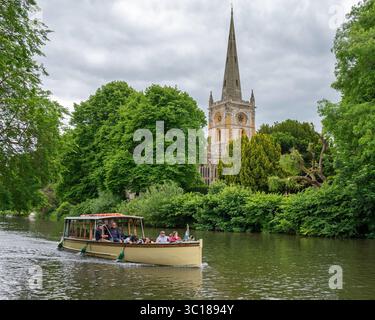 Bootstour auf dem Fluss Avon mit dem Turm der Heiligen Dreifaltigkeitskirche durch die Bäume in Stratford-upon-Avon, Warwickshire, England, Großbritannien. Stockfoto