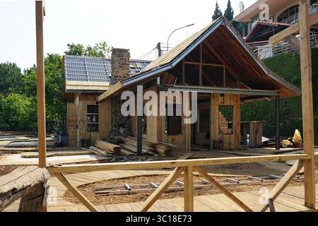 In da Lat wird ein charmantes Holzhaus mit freiliegenden Holzwänden und einer gerahmten Terrasse im Vordergrund gebaut Stockfoto
