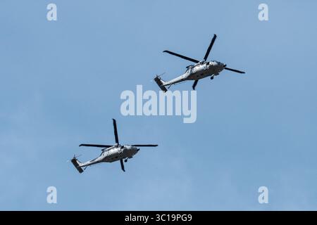 Zwei US Army UH-60M Black Hawk Hubschrauber fliegen zusammen am Himmel Stockfoto