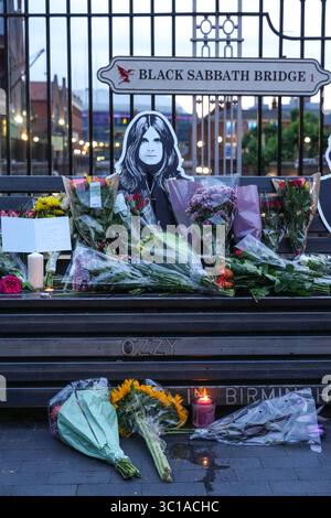 Broad Street, Birmingham, 22. Juli 2025: Fans von Ozzy Osbourne kommen zur Black Sabbath Bridge in Birmingham, um Ozzy Osbourne, der im Alter von 76 Jahren gestorben ist, ihre Anerkennung zu zollen. Blumen, Karten und Kerzen wurden auf der Bank gelassen und einige Leute tranken und teilten sie mit dem Bild von Ozzy auf der Bank. Quelle: British News und Media/Alamy Live News Stockfoto