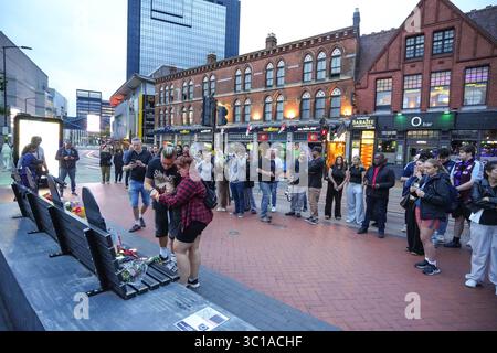 Broad Street, Birmingham, 22. Juli 2025: Fans von Ozzy Osbourne kommen zur Black Sabbath Bridge in Birmingham, um Ozzy Osbourne, der im Alter von 76 Jahren gestorben ist, ihre Anerkennung zu zollen. Blumen, Karten und Kerzen wurden auf der Bank gelassen und einige Leute tranken und teilten sie mit dem Bild von Ozzy auf der Bank. Quelle: British News und Media/Alamy Live News Stockfoto