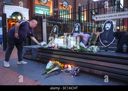 Broad Street, Birmingham, 22. Juli 2025: Fans von Ozzy Osbourne kommen zur Black Sabbath Bridge in Birmingham, um Ozzy Osbourne, der im Alter von 76 Jahren gestorben ist, ihre Anerkennung zu zollen. Blumen, Karten und Kerzen wurden auf der Bank gelassen und einige Leute tranken und teilten sie mit dem Bild von Ozzy auf der Bank. Quelle: British News und Media/Alamy Live News Stockfoto