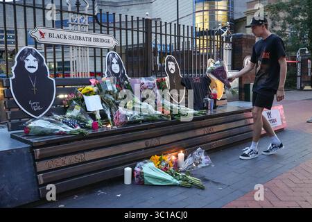 Broad Street, Birmingham, 22. Juli 2025: Fans von Ozzy Osbourne kommen zur Black Sabbath Bridge in Birmingham, um Ozzy Osbourne, der im Alter von 76 Jahren gestorben ist, ihre Anerkennung zu zollen. Blumen, Karten und Kerzen wurden auf der Bank gelassen und einige Leute tranken und teilten sie mit dem Bild von Ozzy auf der Bank. Quelle: British News und Media/Alamy Live News Stockfoto