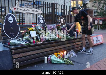 Broad Street, Birmingham, 22. Juli 2025: Fans von Ozzy Osbourne kommen zur Black Sabbath Bridge in Birmingham, um Ozzy Osbourne, der im Alter von 76 Jahren gestorben ist, ihre Anerkennung zu zollen. Blumen, Karten und Kerzen wurden auf der Bank gelassen und einige Leute tranken und teilten sie mit dem Bild von Ozzy auf der Bank. Quelle: British News und Media/Alamy Live News Stockfoto