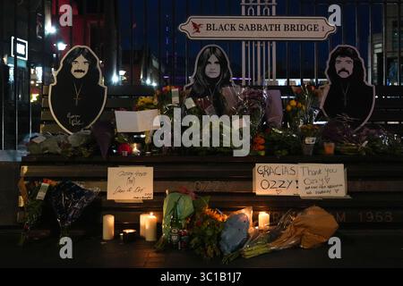 Broad Street, Birmingham, 22. Juli 2025: Fans von Ozzy Osbourne kommen zur Black Sabbath Bridge in Birmingham, um Ozzy Osbourne, der im Alter von 76 Jahren gestorben ist, ihre Anerkennung zu zollen. Blumen, Karten und Kerzen wurden auf der Bank gelassen und einige Leute tranken und teilten sie mit dem Bild von Ozzy auf der Bank. Quelle: British News und Media/Alamy Live News Stockfoto