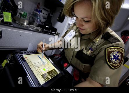 17. Mai 2012 – Minneapolis, MN – Minnesota, USA – USA – Mari Hill, Sanitäter des Hennepin County Medical Center, demonstrierte am 17. Mai 2012 das SafetyPad auf dem HCMC in Minneapolis, MN. â€¢ Ein Unternehmen namens OPEN Inc. Von Edina bietet Software für Notmediziner und Feuerwehren. Wir benötigen ein Foto von einem Notfalltechniker des Hennepin County Medical Center, der die Software auf einem Tablet-Computer namens SafetyPad verwendet. Das SafetyPad dient zur Erfassung von Informationen für die Patientenbehandlung und die Versicherungsabrechnung. (Bild: Joel Koyama/Minneapolis Stockfoto