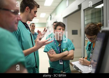 NEAPOLIS - 11/17/09 - das Hennepin County Medical Center, das mehr arme Menschen als jedes andere Krankenhaus im Bundesstaat versorgt, aber auch renommierte Ausbildungs- und Spezialdienstleistungen betreibt, liegt im Herzen der Gesundheitskosten des Bundesstaates. AUF DIESEM FOTO: Dr. Chad Roline, der zweite von links, informierte die Nachtmannschaft über die Patienten, die sie während ihrer Schicht betreuen würden. Dr. Sarah Bronner machte sich Notizen, während Dr. Bill Heegaard zuhörte. Auf der linken Seite war Dr. Dave Plummer. (Bild: Jeff Wheeler/Minneapolis Star Tribune/TNS via ZUMA Wire) Stockfoto