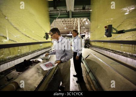 18. Juli 2011: Faribault, MN, USA, von links haben Cousins Paul und Chuck Mooty die geschlossene Faribault Woolen Mill gekauft und planen, sie bald wieder zu eröffnen. Sie standen zwischen zwei Webstühlen, die bei der Betriebsstilllegung 2009 während einer Besichtigung des historischen Gebäudes in Faribault, Minn., am Montag, den 18. Juli 2011 gestoppt wurden. (/STAR TRIBUNE) Paul Mooty, Chuck Mooty (Kreditbild: Renee Jones Schneider/Minneapolis Star Tribune/TNS via ZUMA Wire) Stockfoto