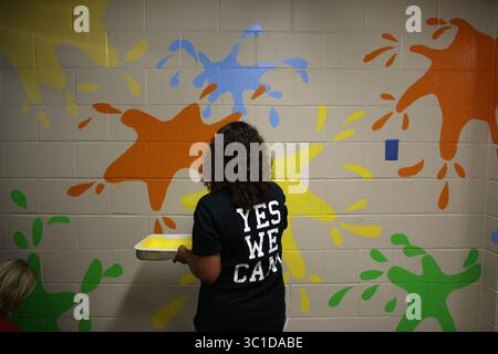 19. August 2014 - Brooklyn Park, MN, USA - Angi Stoltzmann, Mathematiklehrerin der 5. Klasse, hat einen zweiten Anstrich auf die kunstvollen Spritzer an einer der Flurwände aufgetragen. (/STAR TRIBUNE) während eines Tages der „Verschönerung“ an der Northport Elementary School in Brooklyn Park, Min., Dienstag, 19. August, 2014. (Bild: Kyndell Harkness/Minneapolis Star Tribune/TNS via ZUMA Wire) Stockfoto