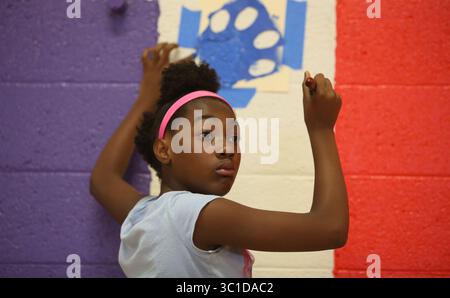 19. August 2014 - Brooklyn Park, MN, USA - Jamiah Ward, 10, die dieses Jahr fünfte Klasse werden wird, füllte einen Schablonenpfotendruck aus, der die Wände im Fitnessstudio schmückte. (/STAR TRIBUNE) während eines Tages der „Verschönerung“ an der Northport Elementary School in Brooklyn Park, Min., Dienstag, 19. August, 2014. (Bild: Kyndell Harkness/Minneapolis Star Tribune/TNS via ZUMA Wire) Stockfoto
