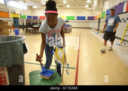19. August 2014 - Brooklyn Park, MN, USA - Jamiah Ward, 10, die dieses Jahr fünfte Klasse werden wird, bekam mehr Farbe auf ihrem Busch, um einen Schablonenfotendruck zu füllen, der die Wände im Fitnessstudio schmückte. (/STAR TRIBUNE) während eines Tages der „Verschönerung“ an der Northport Elementary School in Brooklyn Park, Min., Dienstag, 19. August, 2014. (Bild: Kyndell Harkness/Minneapolis Star Tribune/TNS via ZUMA Wire) Stockfoto