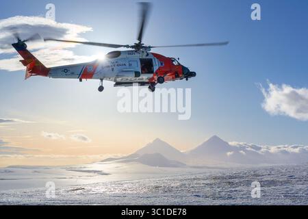 7. Februar 2019 - Cold Bay, Alaska, USA - Eine Küstenwache der Luftstation Kodiak MH-60 Jayhawk Hubschrauberflugzeuge fliegen über einen aktiven Vulkan in der Nähe von Cold Bay, Alaska, 7. Februar 2019. Während der harten Wintermonate Alaskas werden die Flugzeuge nach Cold Bay geschickt, um die Reaktionszeiten für Such- und Rettungsfälle zu verkürzen. (Bild: © U.S. Coast Guard/ZUMA Wire/ZUMAPRESS.com) Stockfoto