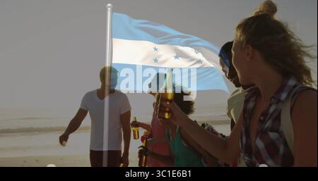 Fünf Freunde spazieren, plaudern mit Bierflaschen am Strand bei Sonnenuntergang, mit blau weiß gestreifter Flagge Stockfoto