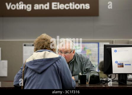 23. Oktober 2014 – Minneapolis, MN, USA – Andrew Krueger, Spezialist für das Wahlbüro im Hennepin County, USA, half der Wählerin Mary Ellen Gallick bei ihren Wahlabstimmungen im Hennepin County Government Center am Donnerstag, 23. Oktober 2014 in Minneapolis, MN. (/STAR TRIBUNE) (Bild: Elizabeth Flores/Minneapolis Star Tribune/TNS via ZUMA Wire) Stockfoto