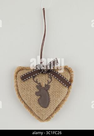 Sacktuch gebunden mit Schleife und Herzform hängt für Weihnachtsdekoration isolierter Naturhintergrund mit Schneidepfad Stockfoto