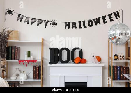 Disco Ball und Halloween Dekoration am Kamin in der Nähe der weißen Wand zu Hause Stockfoto